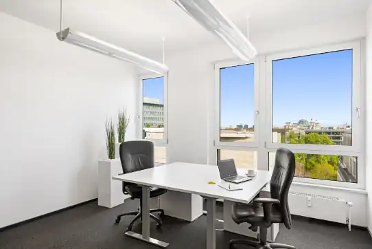 Modernes Büro mieten mit Tisch und Stühlen.